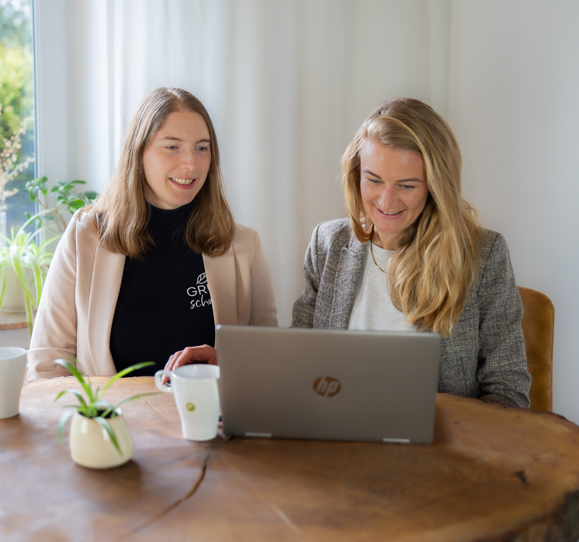 Gründerinnen gucken auf Laptop-Bildschirm